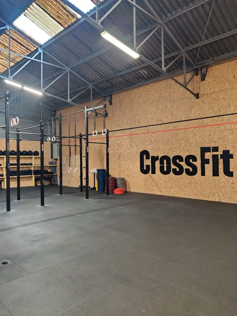 L'espace d'entraînement de la salle, avec ses racks et le logo CrossFit au mur